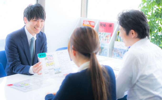 写真：店内で物件を紹介中の男性スタッフ